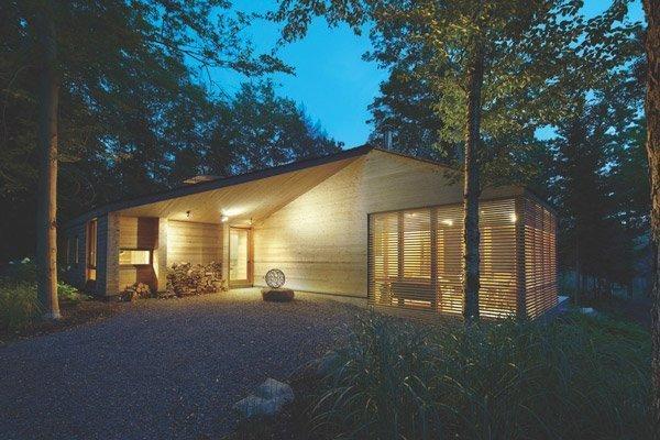 A small house with cedar siding and window shades